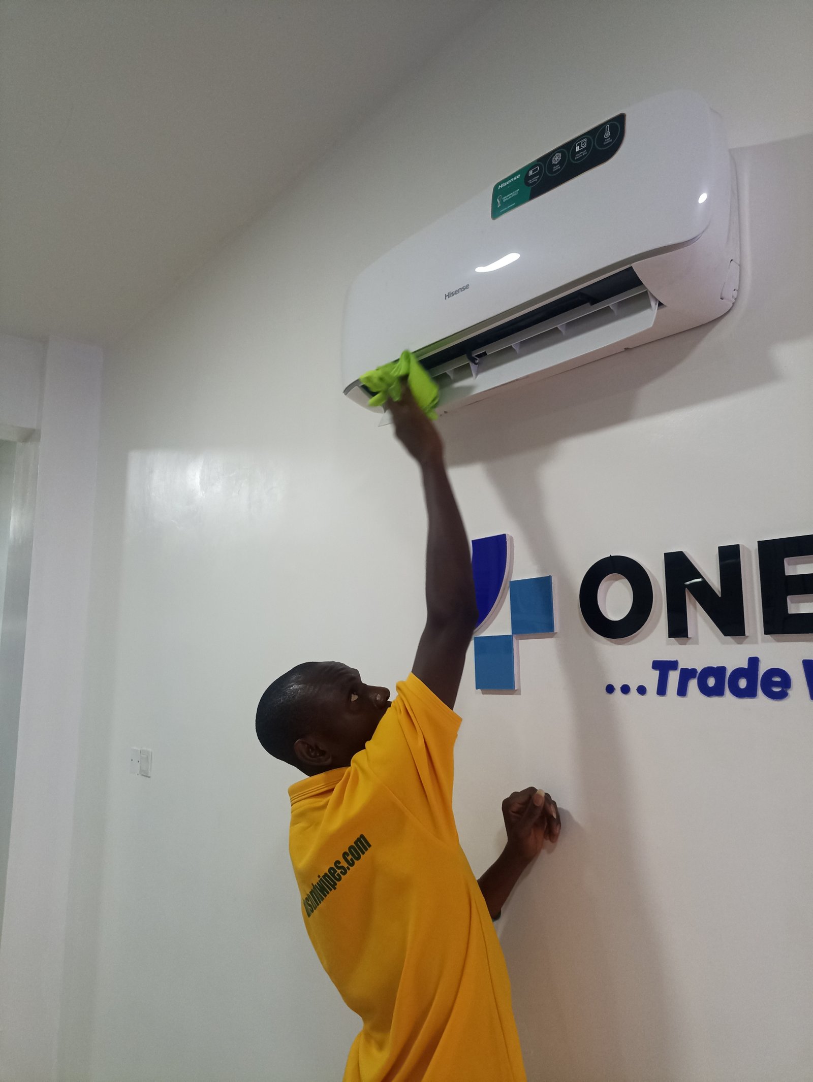 Dust and Wipes staff cleaning an air conditioning unit in an office in Abuja